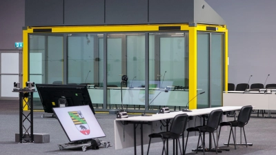 Ein Blick in den Gerichtssaal auf den Platz für die Zeugen und die Glaskabine, in der der Angeklagte während der Verhandlungen sitzt. (Archivbild)  (Foto: Jan Woitas/dpa)