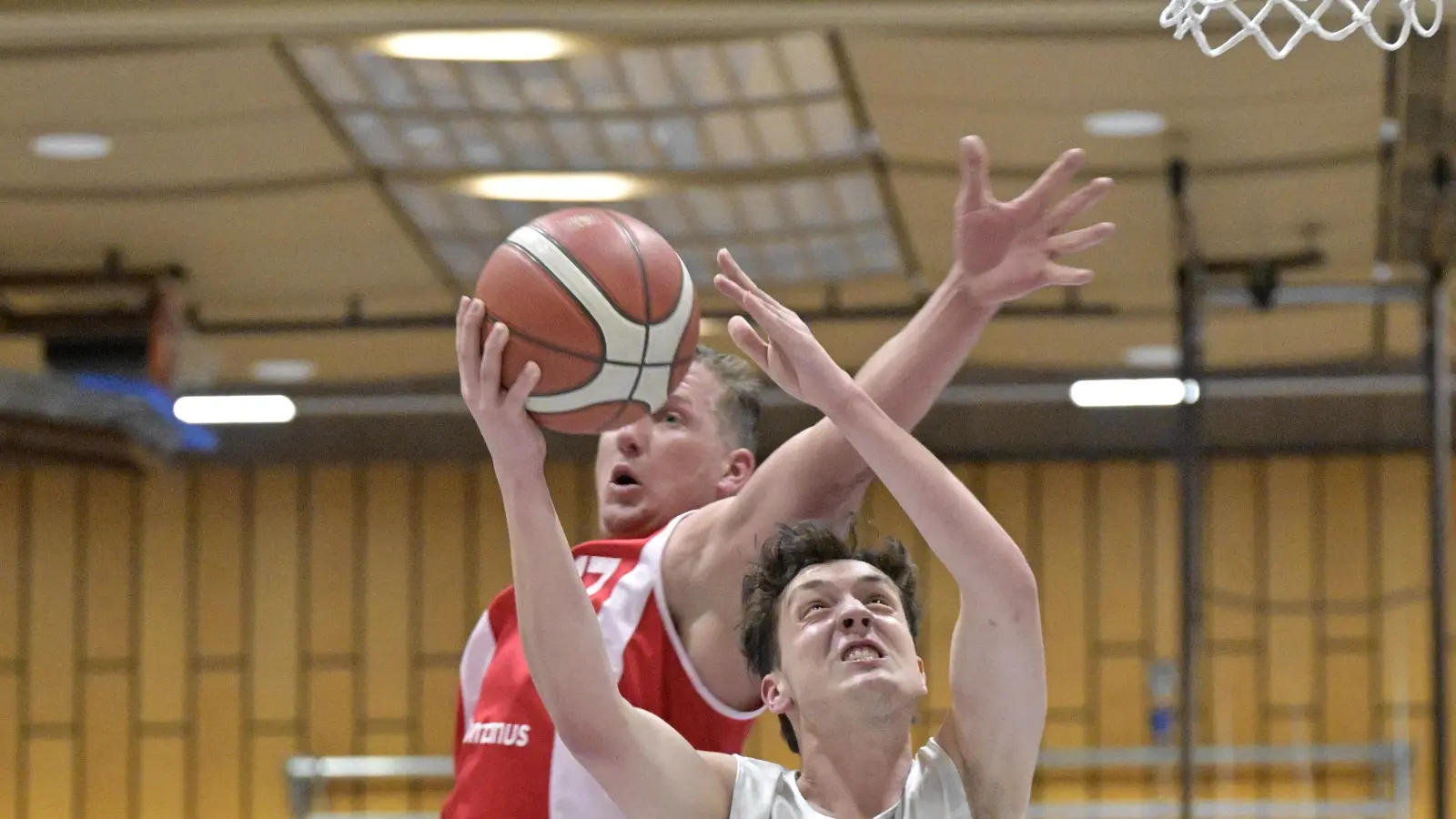Nicholas Gottschalk (vorne in weiß) setzt sich hier gegen den Nördlinger Josef Eichler durch. Insgesamt steuerte der Nachwuchsspieler acht Punkte und zwei entscheidende Dreier zum Sieg seiner Neustädter bei. (Foto: Martin Rügner)