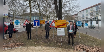 Der Künstler Johannes Volkmann (vorne rechts) hat die „Verkehrsschilder der Gerechtigkeit“ zusammen mit Kindern gestaltet. Das Projekt unterstützen Kulturreferentin Nadja Wihelm, Schulleiter Stefan Exner, Oberbürgermeister Thomas Deffner und die Literaturexpertin Bettina Baumann (hinten von links). (Foto: Lara Hausleitner)
