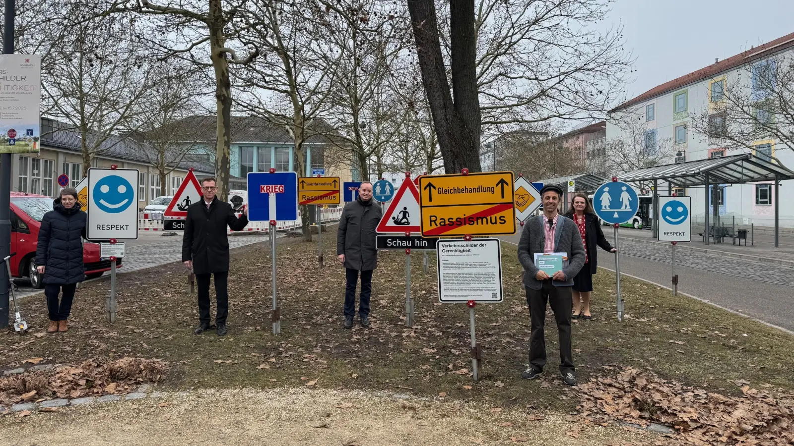 Der Künstler Johannes Volkmann (vorne rechts) hat die „Verkehrsschilder der Gerechtigkeit“ zusammen mit Kindern gestaltet. Das Projekt unterstützen Kulturreferentin Nadja Wihelm, Schulleiter Stefan Exner, Oberbürgermeister Thomas Deffner und die Literaturexpertin Bettina Baumann (hinten von links). (Foto: Lara Hausleitner)