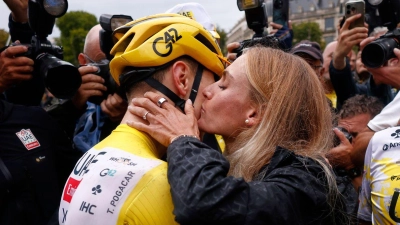 Tour-Sieger Tadej Pogacar küsst seine Partnerin Urska Zigart. (Foto: Yoan Valat/Pool EPA/AP/dpa)
