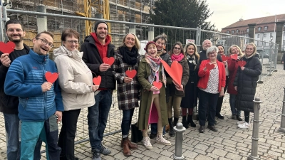 Sie alle verteilen Herzen an die Kundschaft: Simon Horand, Thomas Ehrmann, Heidi Schmidt, Michael Fengler, Sneewitta May, Elke Knöbl, Elke Homm-Vogel, Laura Graf, Jasmin Tzouvaras, Jürgen Wolf, Edith Thiemer, Manuela Trapp, Angela Engerer und Ann-Kathrin Hartmann (von links). (Foto: Florian Pöhlmann)