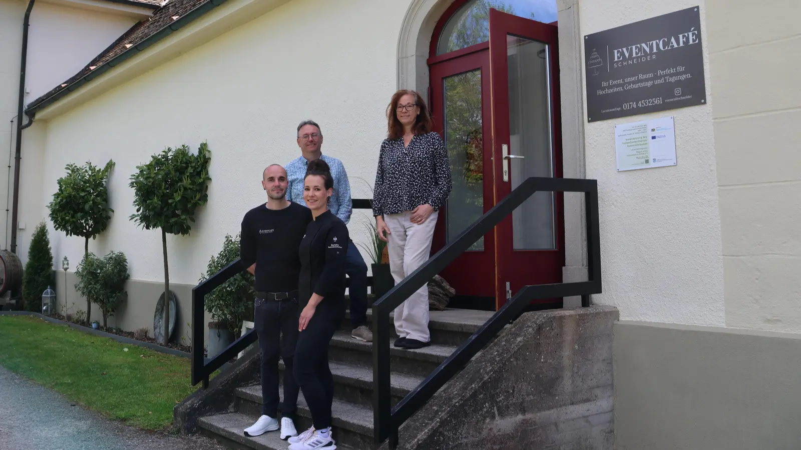 Manuel und Sarah Schneider (vorne) vor ihrem neuen Event-Café im ehemaligen Vorderbreitenthanner Schulhaus. Die beiden wurden von der LAG Romantische Straße unterstützt. Deren Vorsitzender Herbert Lindörfer und Geschäftsführerin Pia Grimmeißen-Haider besuchten das neue gastronomische Angebot kurz vor der Eröffnung. (Foto: Martina Haas)