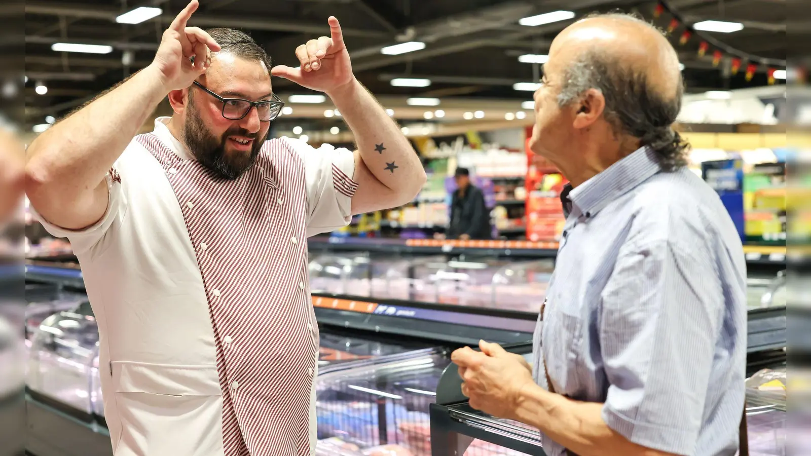 Metzger Yevgeniy Klibanov zeigt die Gebärde für „Rind“.  (Foto: Daniel Löb/dpa)