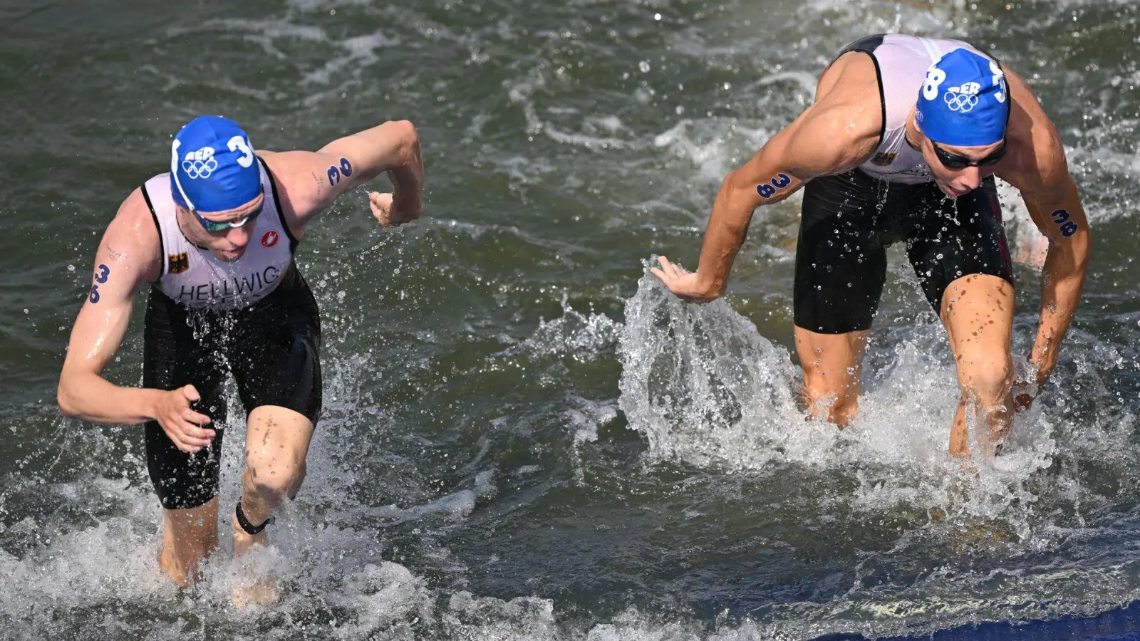 Tim Hellwig und Jonas Schomburg steigen aus der trüben Seine. (Foto: Marijan Murat/dpa)