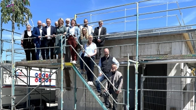 Mitarbeitende der Lebenshilfe Ansbach, Vertreterinnen und Vertreter aus Politik und Verwaltung sowie von den beteiligten Firmen feierten das Richtfest für den Ersatzneubau des Gemeinschaftlichen Wohnens in Herrieden.  (Foto: Lebenshilfe/Nathalie Lober)