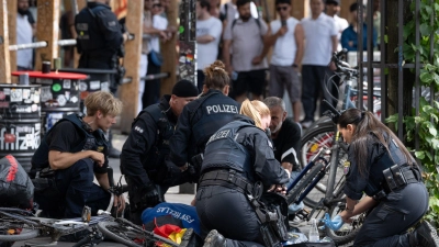 Polizisten knien in der Nähe des Frankfurter Hauptbahnhofs am Boden und kümmern sich um einen Verletzten.  (Foto: Boris Roessler/dpa)