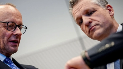 Friedrich Merz und Thorsten Frei mit einem Blick auf die Uhr (Foto: Kay Nietfeld/dpa)