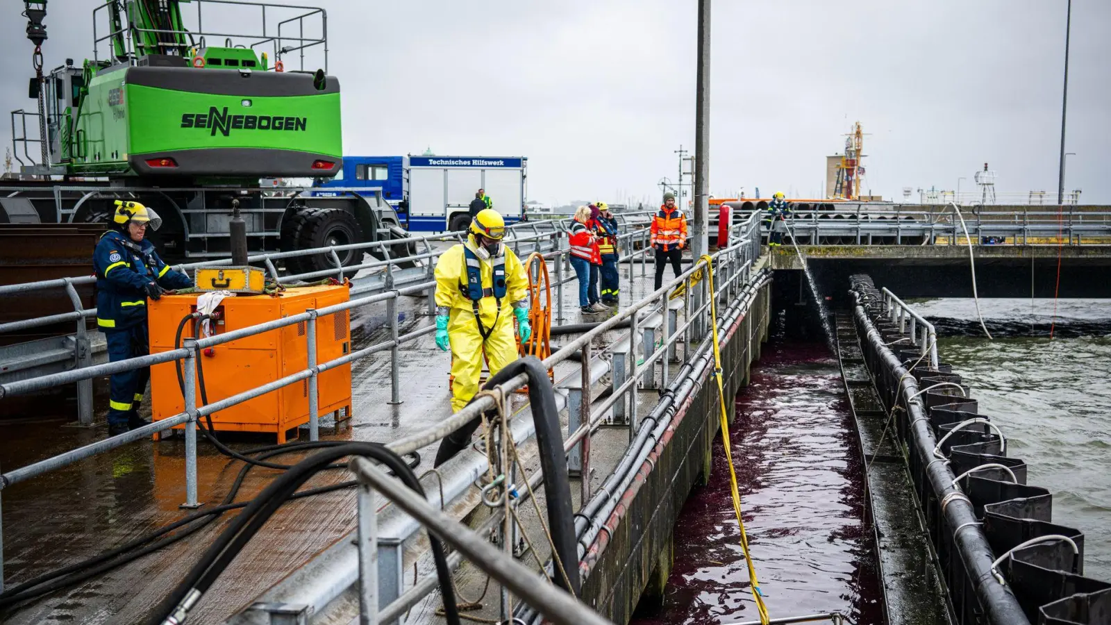 Die Einsatzkräfte schützen sich mit Atemmasken. (Foto: Sina Schuldt/dpa)