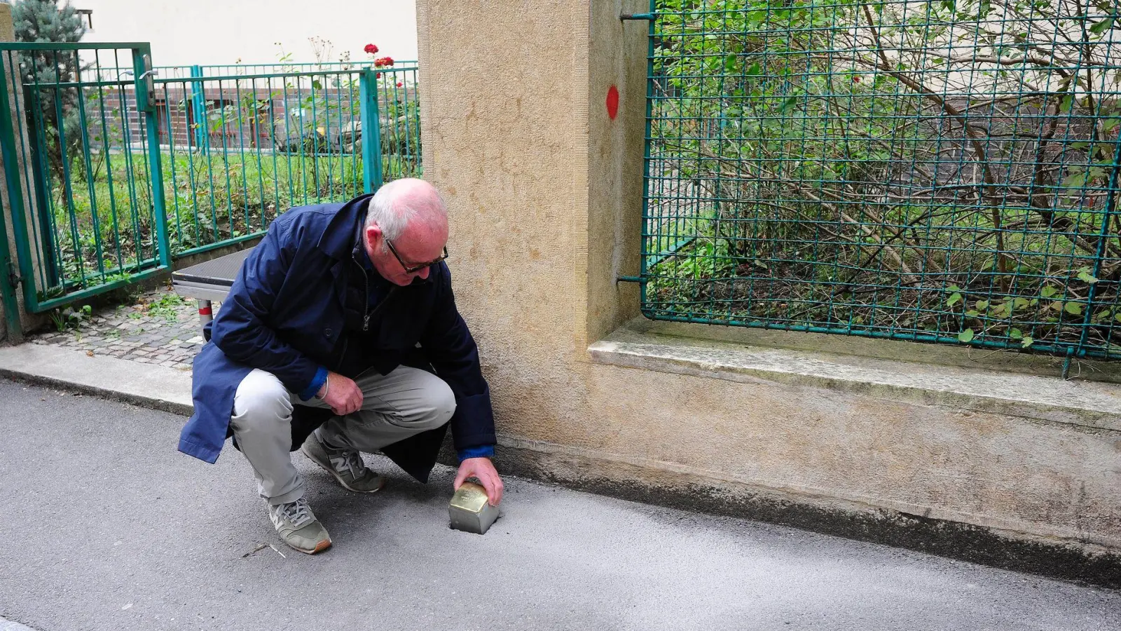 Gregory Tigrid hält den Stolperstein für seinen Vater Pavel Tigrid. In Prag erinnert vor dem Haus Kouřimská 5 ein neuer Stolperstein an den tschechischen Schriftsteller und Ex-Kulturminister Pavel Tigrid (1917-2003).  (Foto: Michael Heitmann/dpa)