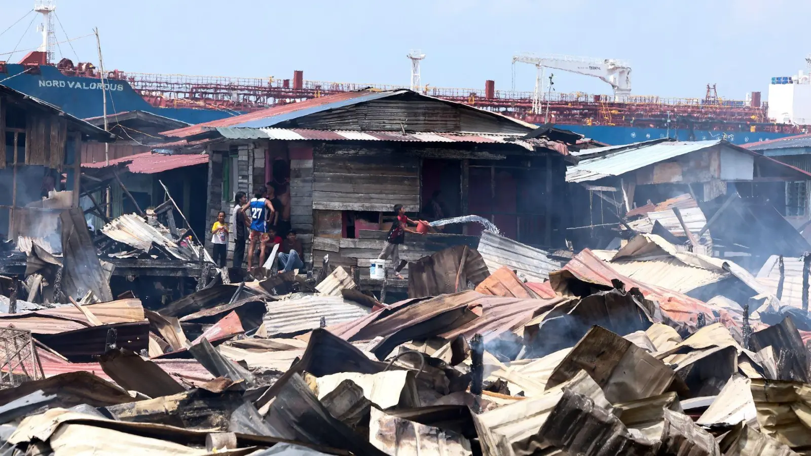 Die Löscharbeiten wurden nach Angaben von Einsatzkräften durch enge Zufahrten, starken Wind und eingeschränkten Zugang zu Wasser bei Ebbe erschwert. (Foto: Bernama/Handout/XinHua/dpa)