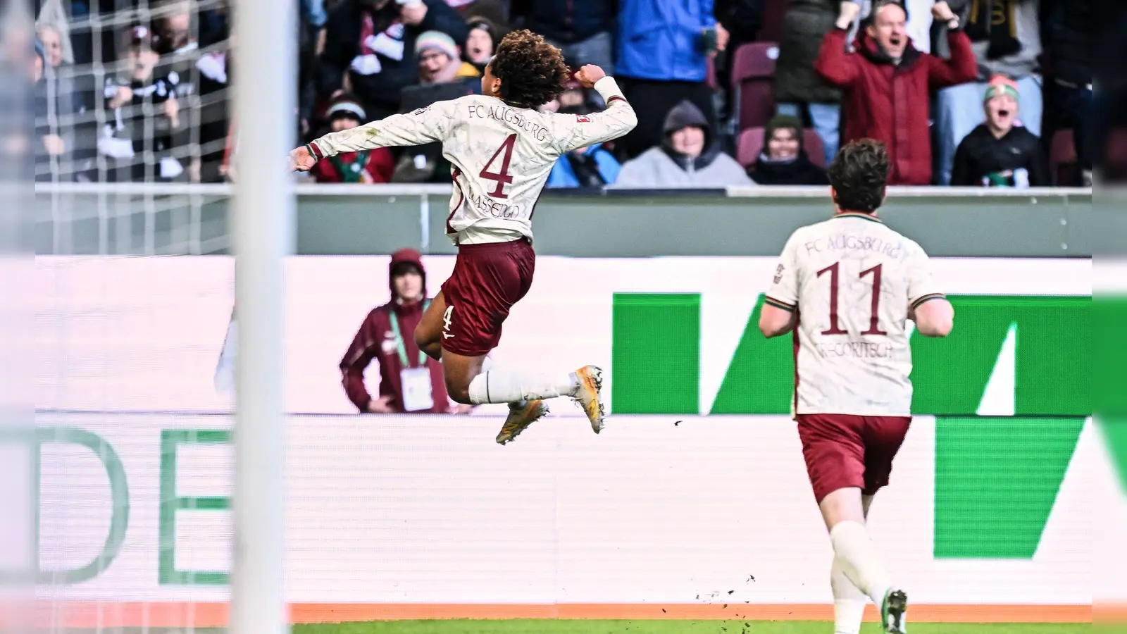 Han-Noah Massengo hebt nach seinem 1:0 jubelnd ab - zum Sieg reichte sein Kopfballtor für den FC Augsburg aber nicht.  (Foto: Harry Langer/dpa)