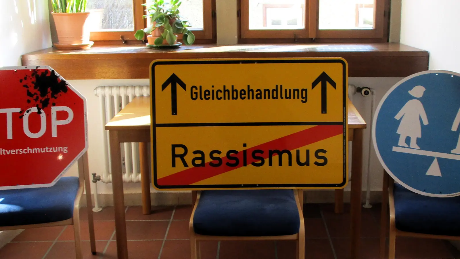 Ein Stoppschild gegen Umweltverschmutzung, ein Ortsschild Richtung Gleichbehandlung und ein Schild für die Gleichberechtigung zwischen Mann und Frau sind drei Beispiele für die Verkehrsschilder der Gerechtigkeit. (Foto: Christine Birmann)