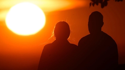 Ein Paar bei Sonnenaufgang (Foto: Julian Stratenschulte/dpa)