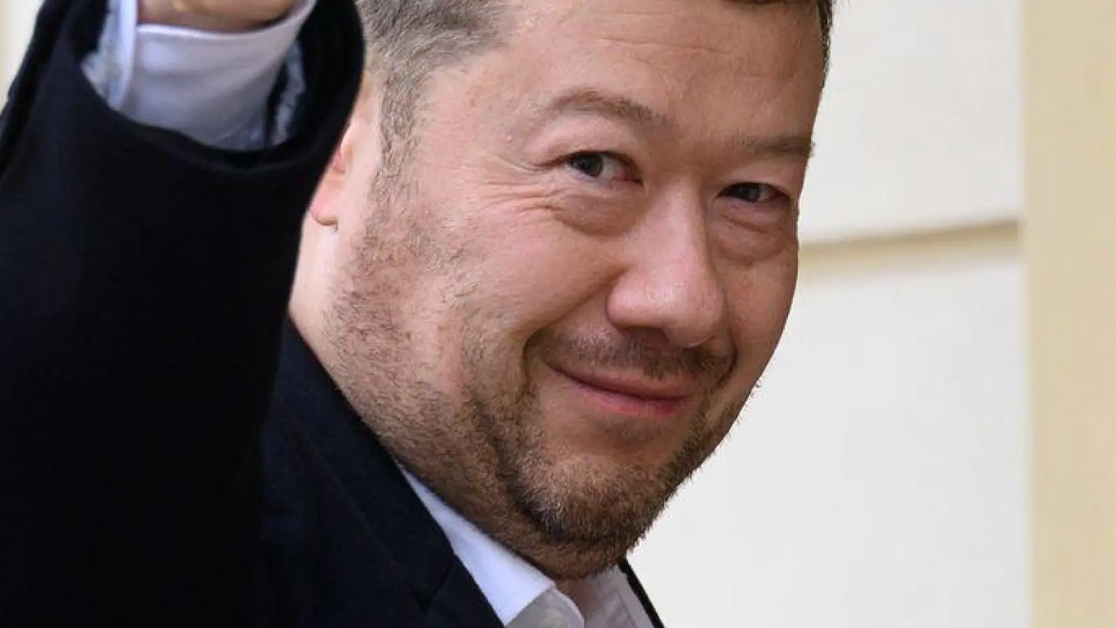 Der Vorsitzende der Partei Freiheit und direkte Demokratie (SPD), Tomio Okamura, begrüßt Fotografen auf seinem Weg zu Präsident Pavel, der ihn zu einer Nachwahlberatung eingeladen hatte. (Foto: Kamaryt Michal/CTK/dpa)