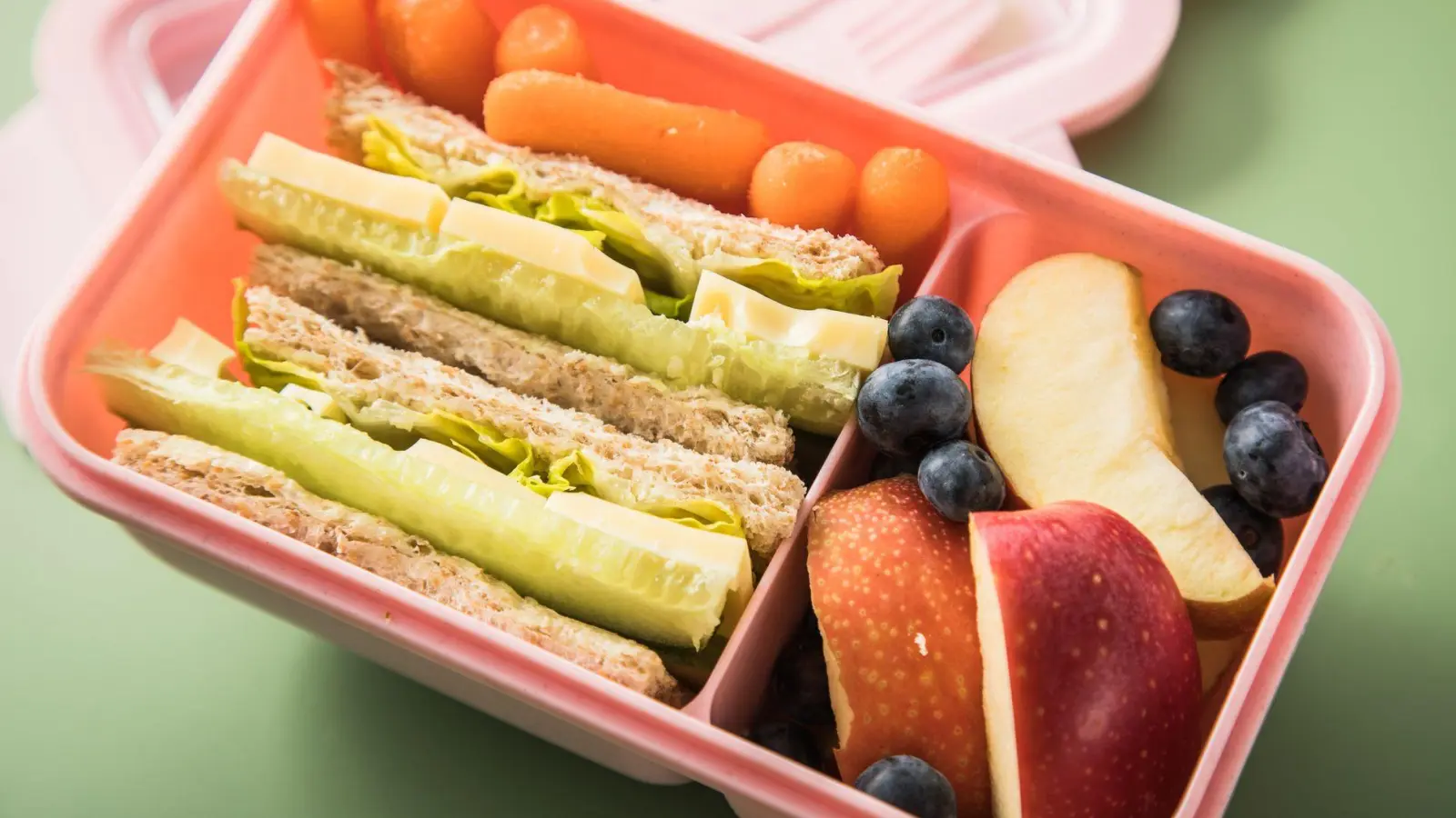 Eine Brotdose mit Vollkorn-Toast als Sattmacher, belegt mit knackigen Gurkenstreifen, Salat sowie Käse als Eiweißportion und dazu reichlich Obst in Form von Blaubeeren und Apfelschnitzen. (Foto: Christin Klose/dpa-tmn)