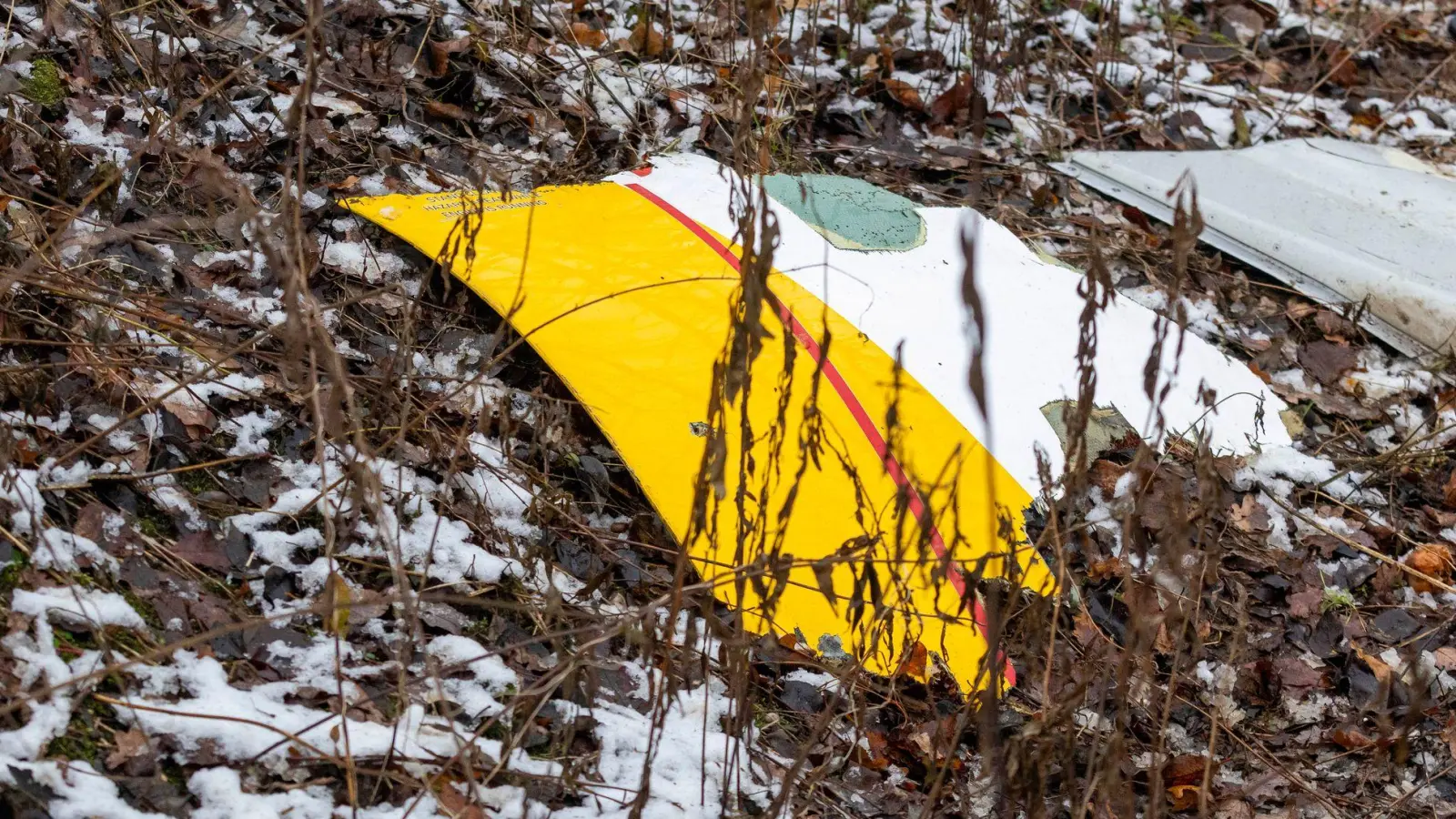 Auf einem Trümmerteil des abgestürzten Flugzeugs sind die DHL-Farben zu sehen. (Foto: Mindaugas Kulbis/AP)