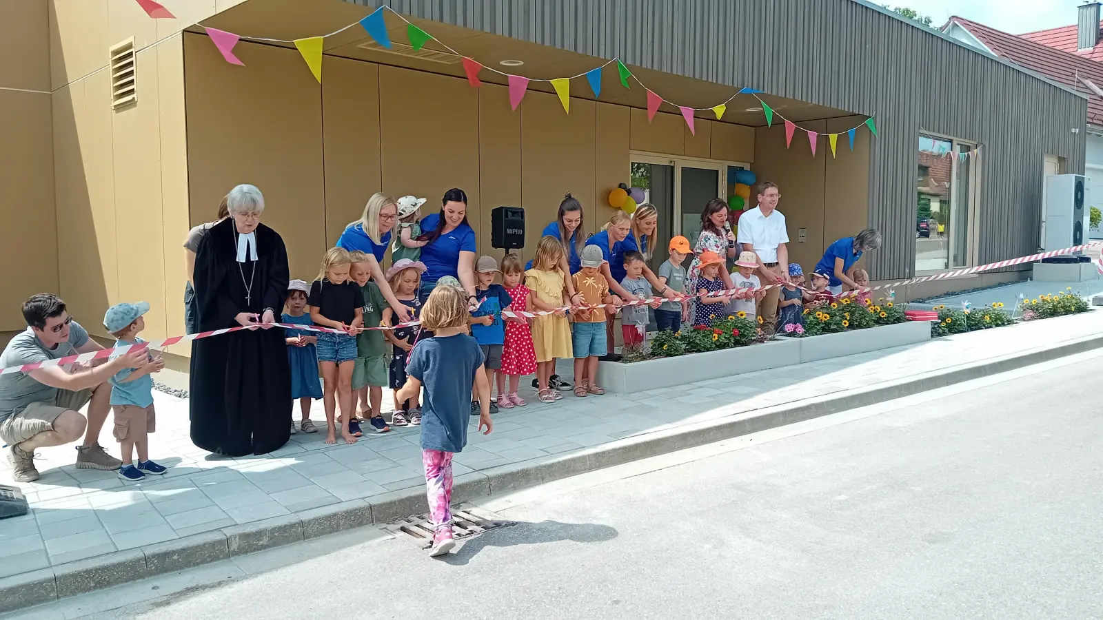 Ein wichtiger symbolischer Moment: Einige Kinder schnitten mit Ehrengästen und Mitarbeiterinnen ein Band durch. (Foto: Susanne Landgraf)
