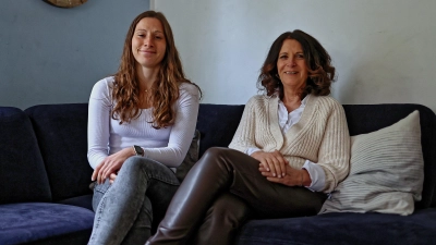 Die Erzieherin und Hausleitung Theresa Hübner (links) und die pädagogische Leitung Dorothee Gehrmann (rechts), beide von der Heilpädagogischen Kinder- und Jugendhilfe (HKJ) Bayern, auf dem Sofa im Wohnzimmer der Wohngruppe. (Foto: Tizian Gerbing)