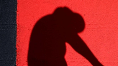 Heute Abend geht es los! Ein Helfer lackiert Kurvensteine in den Farben Schwarz-Rot-Gold. (Foto: Jan Woitas/dpa)