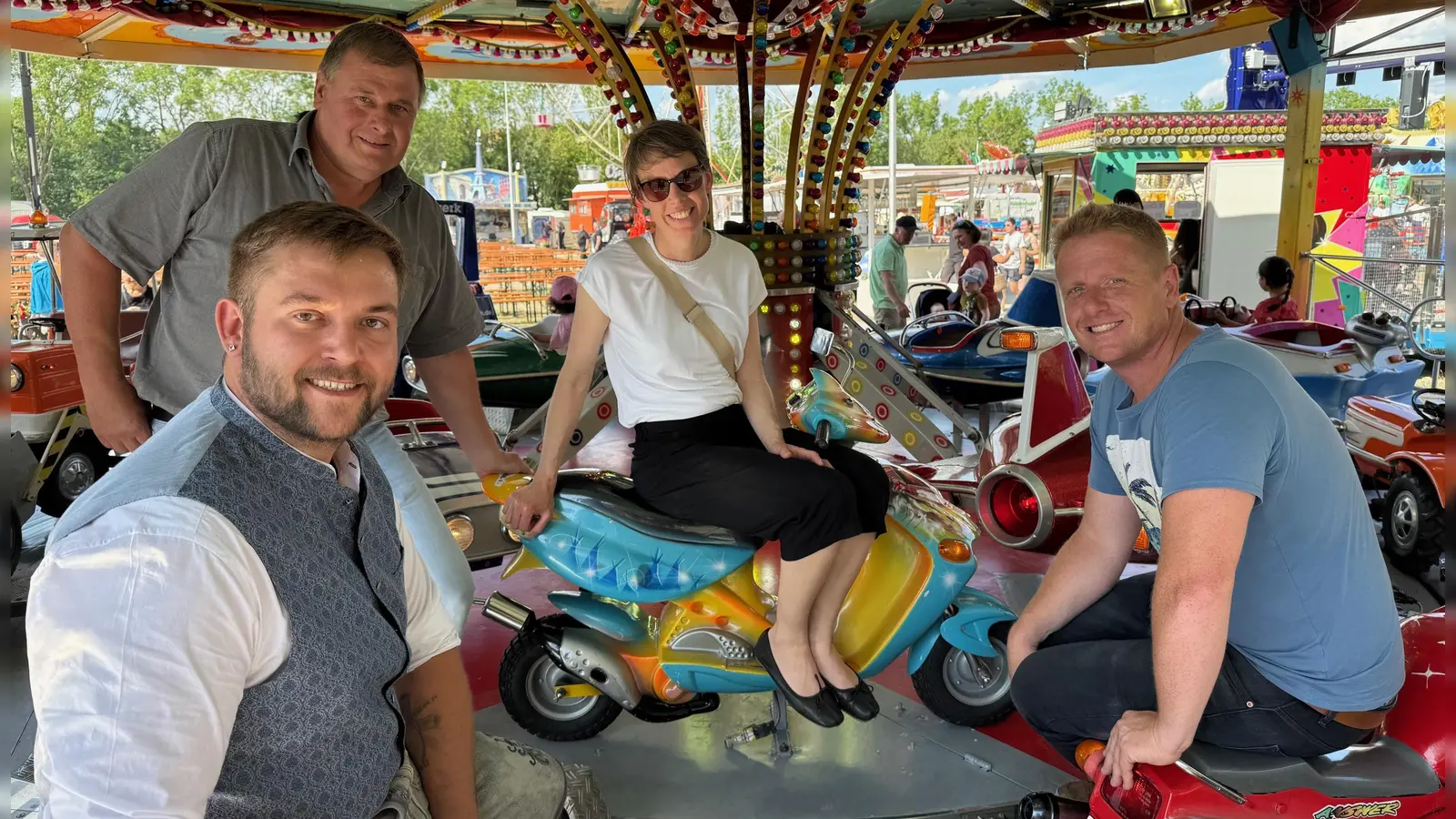 Fotoshooting im Kinderkarussell: Die Veranstalter Sascha Lagemann (links vorne), Pierre Schilling (links hinten) und Curt Eschenbacher freuen sich über den positiven Verlauf des Frühlingsfestes, ebenso Nadja Wilhelm, die städtische Referentin für Kultur und Tourismus. (Foto: Lara Hausleitner)