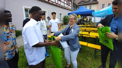 Ursula Kefer, die Leiterin der Hospitalstiftung überreicht Faizou eine Willkommenstasche. Projektleiter Jörg-Simon Löblein (rechts) hat die nächste Tasche schon parat. (Foto: Katrin Merklein)