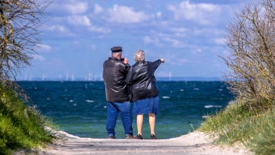 Ein Rentnerpaar steht am ansonsten menschenleeren Strand und schaut aufs Meer. Der Anteil einer jungen Bevölkerung in Deutschland ist weiter rückläufig. (Foto: Jens Büttner/dpa-Zentralbild/dpa)