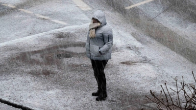 Eine Person steht bei starkem Schneefall an einer Kreuzung in Frankfurt.  (Foto: Boris Roessler/dpa)
