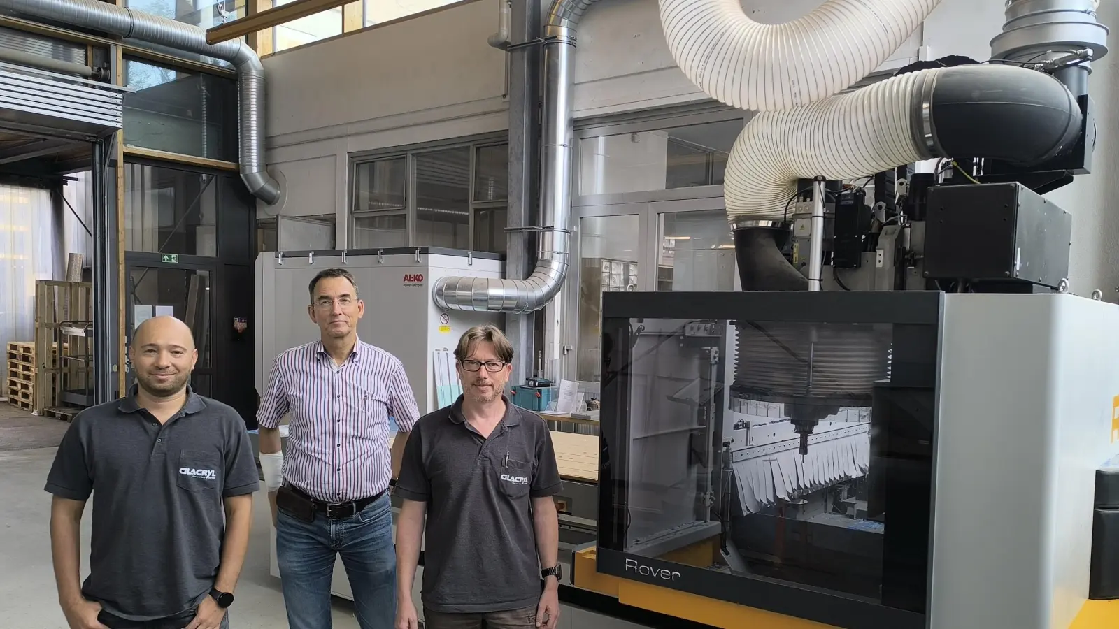 Petro Dikij (links) und Holger Vogel (rechts) haben die Firma Glacryl nach der Insolvenz übernommen. Der frühere Chef Wolfgang Hedel (Mitte) unterstützt sie. Hinter ihnen ist die moderne Maschine zu sehen, die Material in fünf Dimensionen bearbeiten kann.  (Foto: Thomas Schaller)
