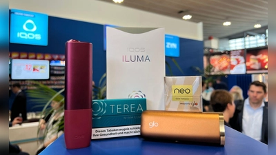 Ein Tabakerhitzer der Marke Iqos vom Hersteller Philip Morris und ein dazugehöriges Päckchen Tabaksticks der Marke Terea sowie das Konkurrenzprodukt Glo (mit Neo-Tabaksticks) des Herstellers BAT liegen bei der Fachmesse Intertabac in einer Messehalle. (Foto: Wolf von Dewitz/dpa)