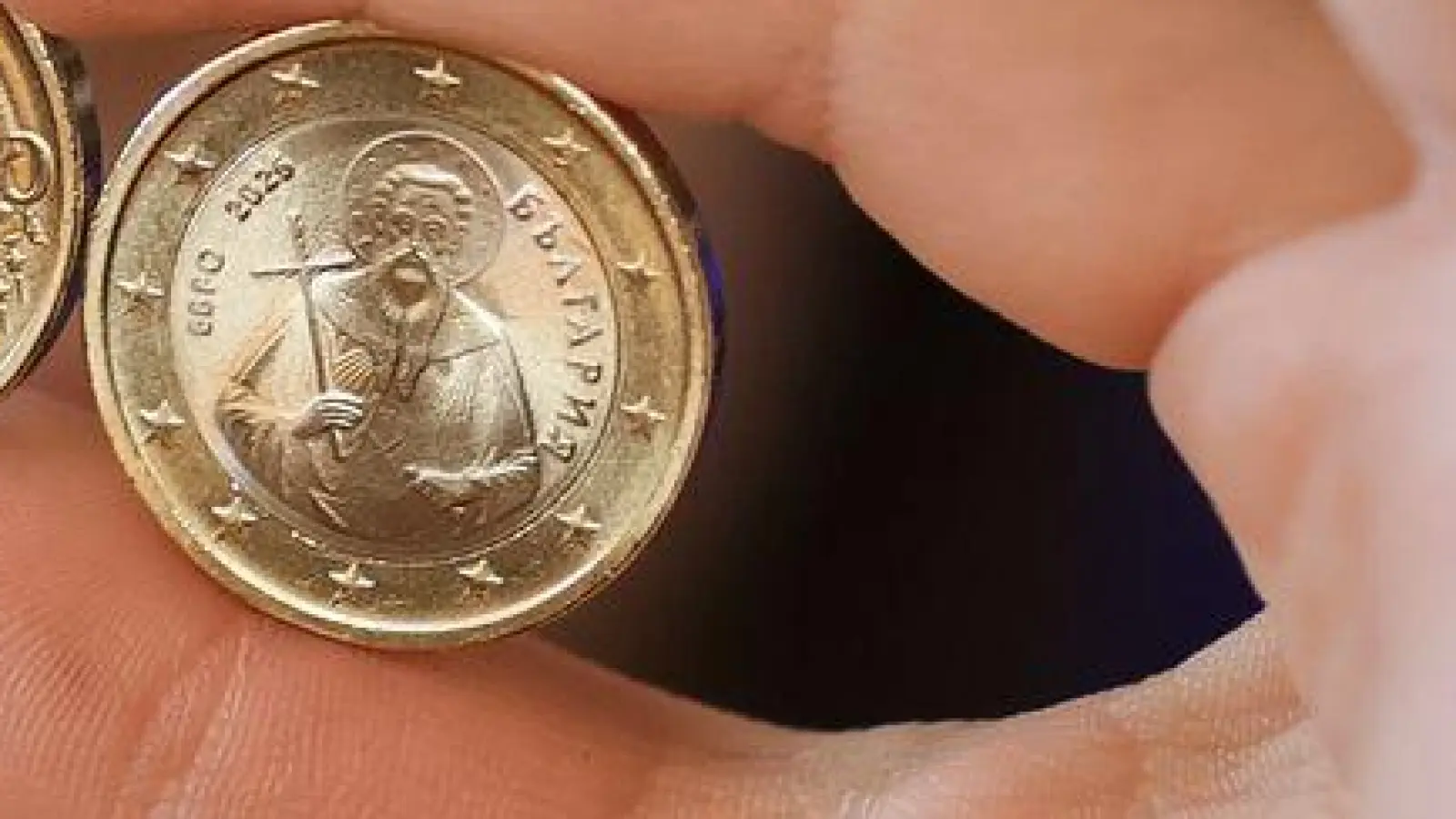 Ein Mädchen zeigt neue Euro-Münzen mit bulgarischen Symbolen. (Foto: Valentina Petrova/AP/dpa)