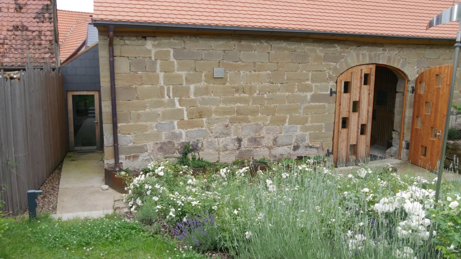 Nicht von der Hauptstraße, sondern von der hinteren Langgasse her, über einen großen Garten kommen die Gäste zur Scheune. Architekt Guido Neubeck, selbst Oberscheinfelder, aber seit langem in Berlin lebend, liebt besonders diese Ansicht mit der wenig veränderten Scheune und dem separaten Zugang zum Backhaus links. (F.: Ganter)