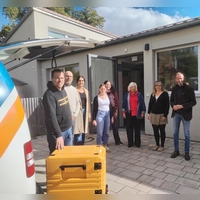 Vor dem Mensaeingang zeigt Fahrer Manuel Ritter (links) den Wärmebehälter der Mahlzeiten den Verantwortlichen des Versorgungskonzepts: (von links) Ron Geyer, Anja Strauß, Anja Beck, Michaela Bernecker, Anne Krebs, Susanne Staib und Dr. Christoph Hammer. (Foto: Michaela Krauth )