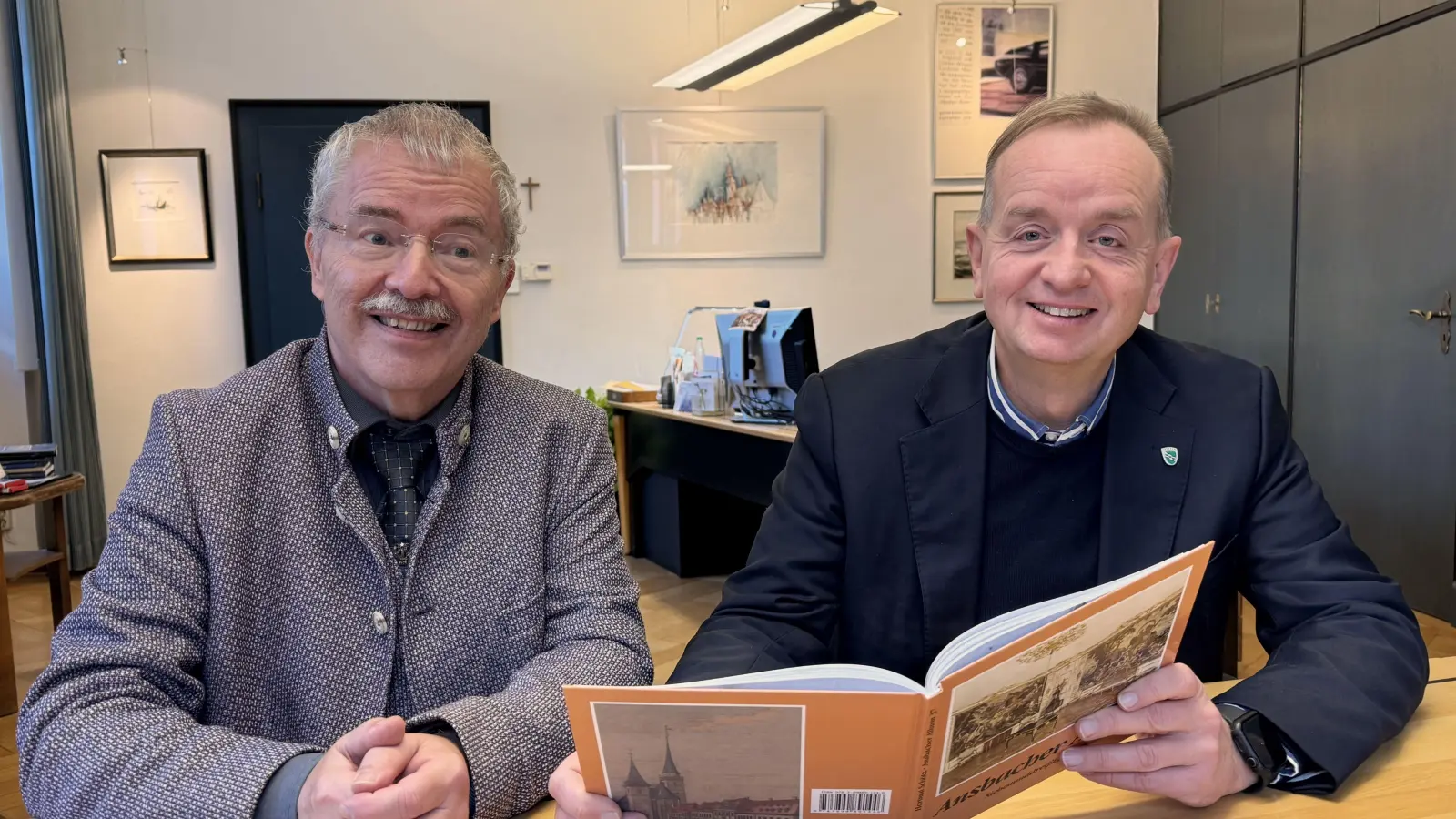 Oberbürgermeister Thomas Deffner (rechts) blättert in Hartmut Schötz’ Werk. (Foto: Oliver Herbst)