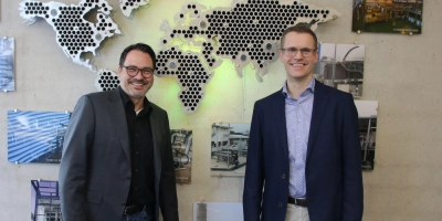 Dr. Markus Heusch (links) und Henning Adelt sind Geschäftsführer bei Aprovis. An der Wand haben Auszubildende weltweite Projekte dargestellt. (Foto: Stefan Neidl)