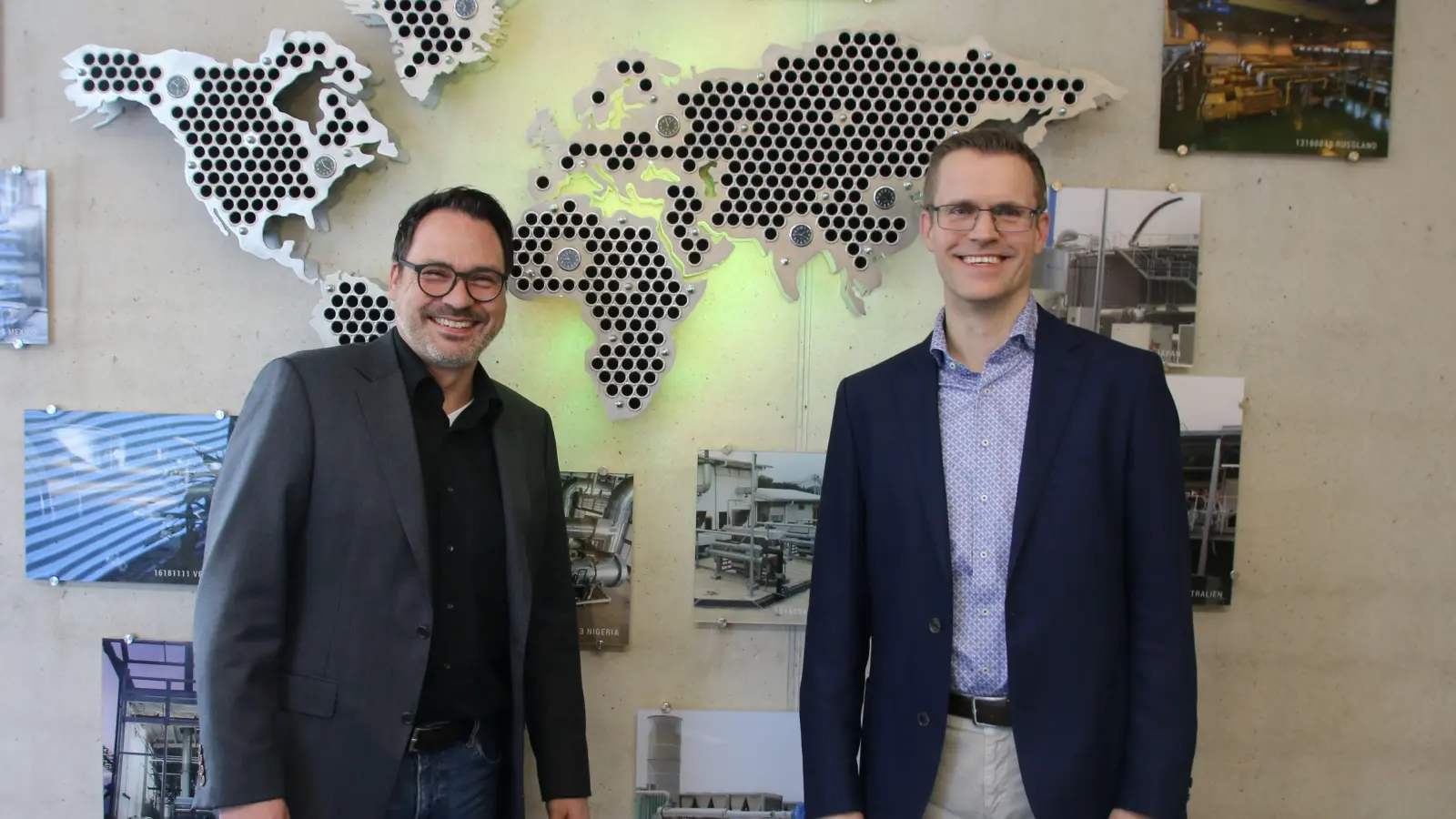 Dr. Markus Heusch (links) und Henning Adelt sind Geschäftsführer bei Aprovis. An der Wand haben Auszubildende weltweite Projekte dargestellt. (Foto: Stefan Neidl)