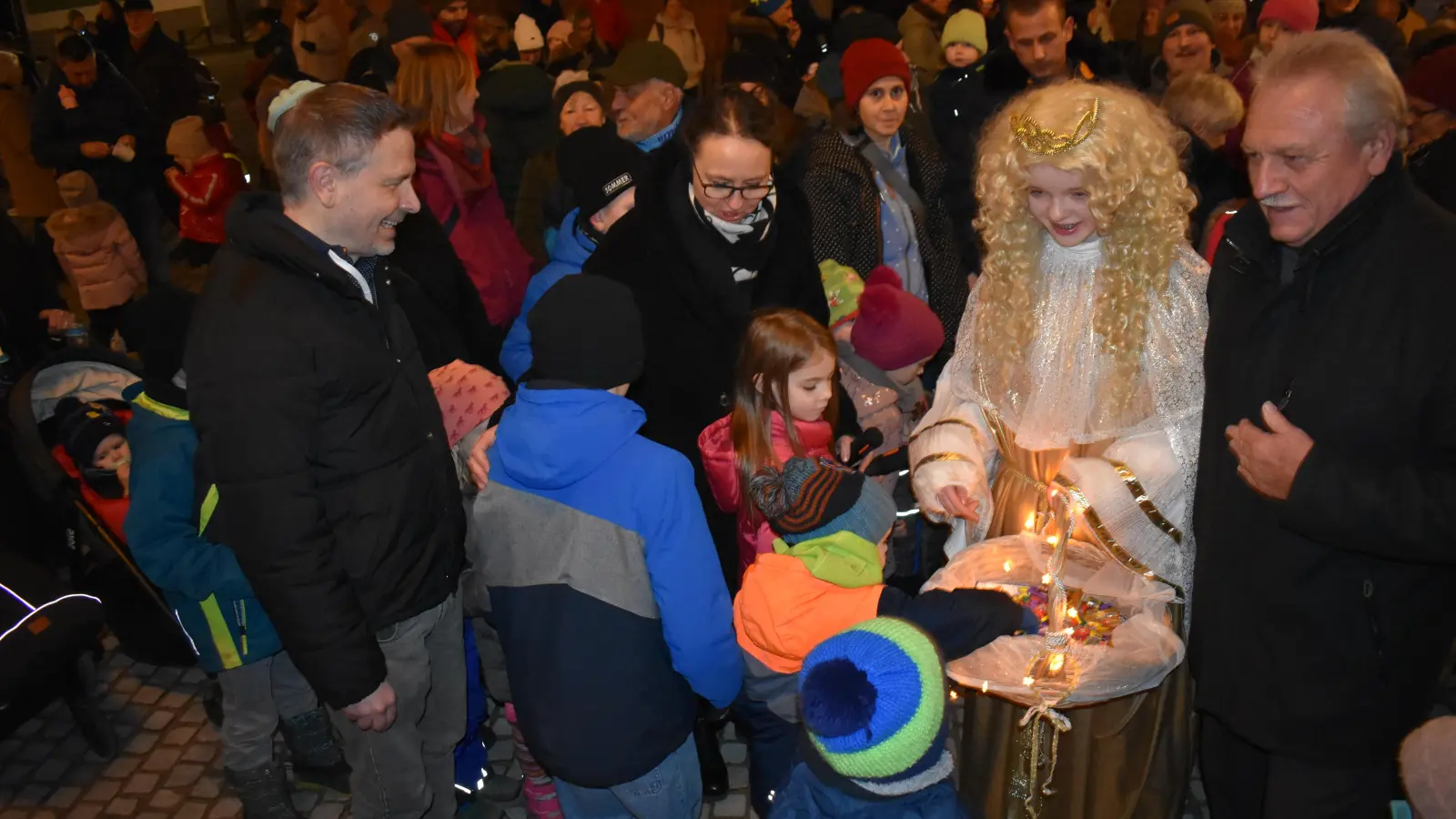 Nach dem Einschalten der Weihnachtsbeleuchtung verteilte das Christkind Süßigkeiten. Klaus Meier (rechts) sowie Elisabeth Seeg-Probst und Oliver Rögner von der Werbegemeinschaft waren auch dabei, kriegten aber keine Süßigkeiten ab. (Foto: Ute Niephaus)