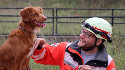 Gut gemacht. Felix Kelm aus Aschheim von der Rettungshundestaffel München lobt Khalunaa. Der Nova Scotia Duck Tolling Retriever hat die Prüfung als Trümmersuchhund wieder bestanden. Alle zwei Jahre müssen die Rettungshunde und ihre Hundeführer ihr Können zeigen, damit sie bei Einsätzen mit dabei sein dürfen.  (Foto: Gudrun Bayer)