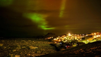 Polarlichter leuchten am frühen Donnerstagmorgen am Himmel über Häusern in Nuuk, Grönland. (Foto: Emilio Morenatti/AP/dpa)