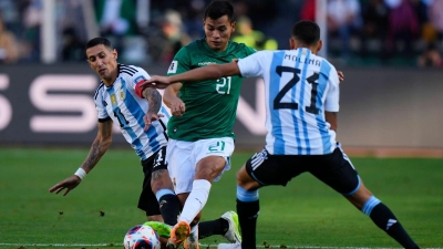 Boliviens Hector Cuellar in Aktion gegen die Argentinier Angel Di Maria (l) und Nahuel Molina (21). (Foto: Juan Karita/AP)