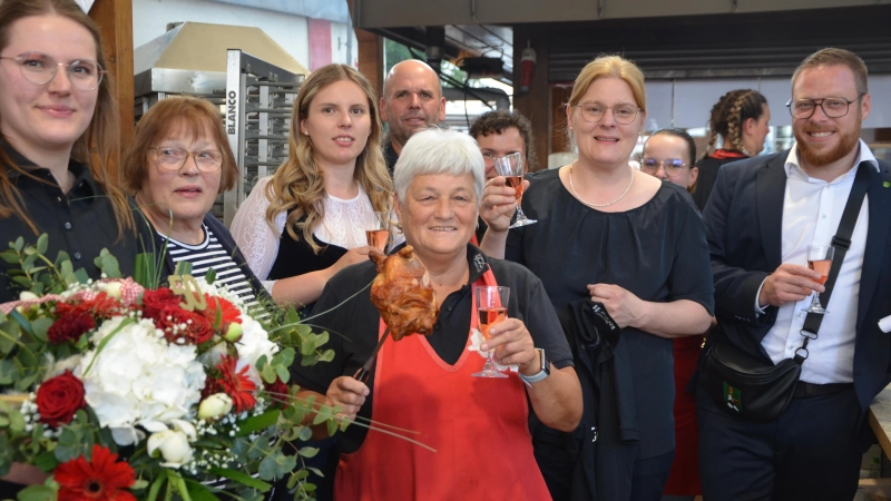 Das ganze Rösch Team feiert ihre „Karin” (vorn im Bild mit dem Hähnchen in der Hand) gratuliert ihr zum 50-jährigen Jubiläum. Auch Neustadts Bürgermeister Alexander Müller (rechts) kam und gratulierte. (Foto: Christa Frühwald)