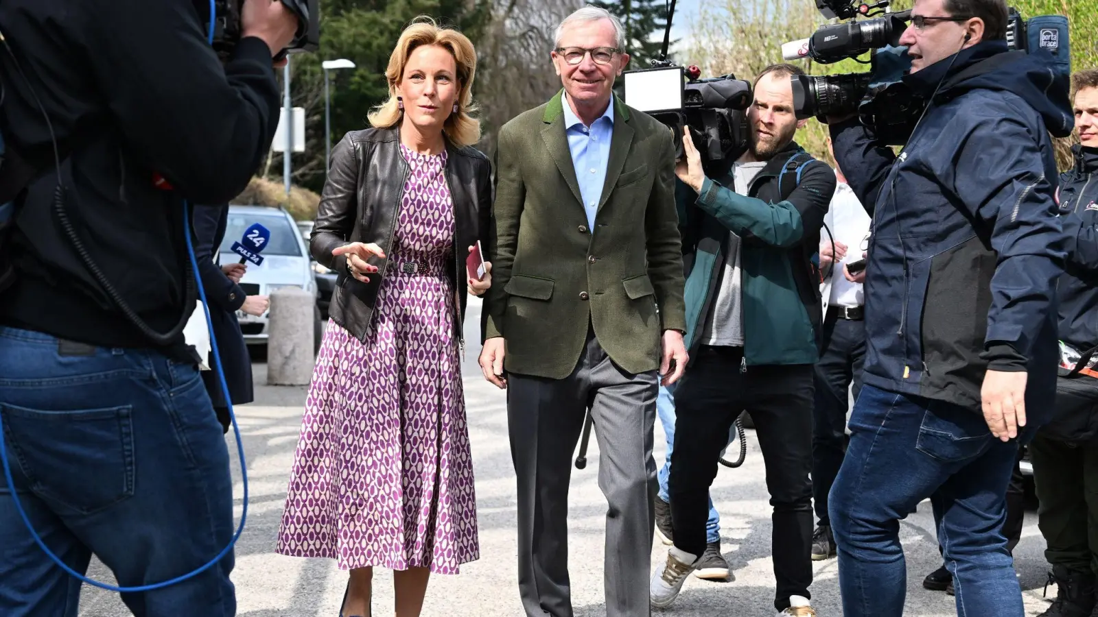 Wilfried Haslauer und seine Frau Christine kommen zwischen Pressevertretern zur Stimmabgabe in ein Wahllokal. (Foto: Barbara Gindl/APA/dpa)