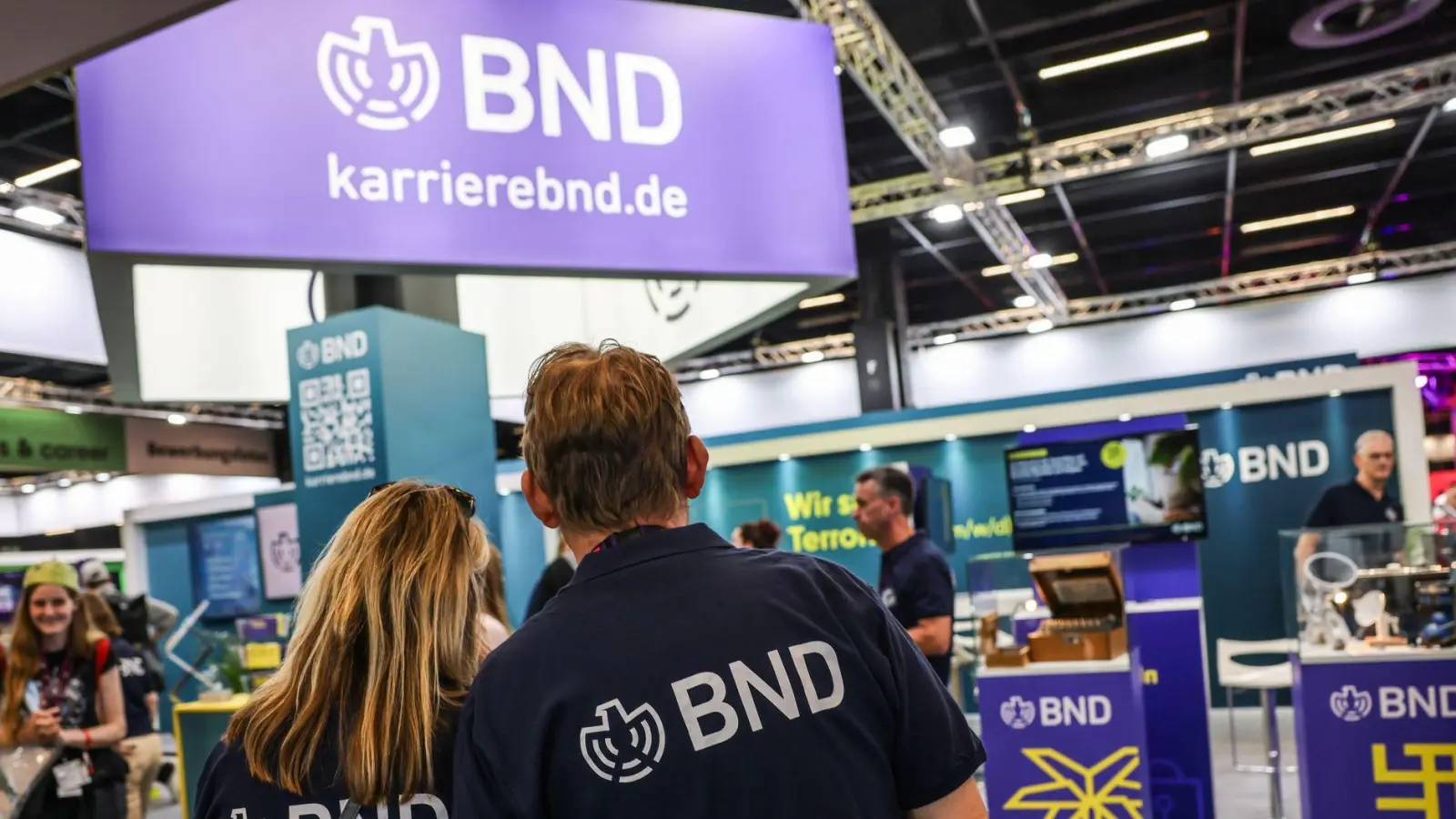 Mitarbeiter des BND stehen am Gamescom-Messestand ihrer Behörde. Die Bundesbehörde zählt circa 6.500 Beschäftigte. (Foto: Oliver Berg/dpa)